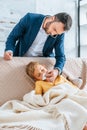 caring father wiping nose of sick