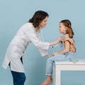 Caring female doctor examining little girl with a stethoscope. Side view. Royalty Free Stock Photo