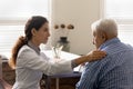 Caring female doctor support old male patient