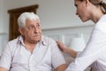 Caring female nurse comfort worried senior male patient Royalty Free Stock Photo