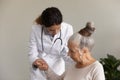 Caring female nurse help old woman patient