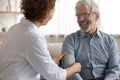 Caring female nurse measure blood pressure of senior patient Royalty Free Stock Photo