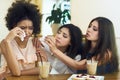 Caring friends supporting young crying woman in cafe