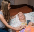 Caring girl holding old lady's hands