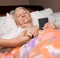 Caring girl holding old lady's hands