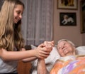 Caring girl holding old lady's hands