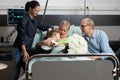 Caring granddaughter hugging sick grandmother while visiting her in hospital ward Royalty Free Stock Photo