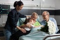 Caring granddaughter hugging sick grandmother while visiting her in hospital ward Royalty Free Stock Photo