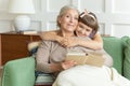 Granddaughter hugging grandmother and reading book