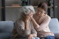Caring grownup daughter comforting frustrated unhappy mature woman