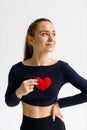 Caring for the heart, cardio training. A young woman takes care of health and holds a red heart in her hands Royalty Free Stock Photo