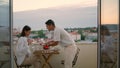 Caring husband serving table hotel balcony closeup. Young couple romantic dinner Royalty Free Stock Photo