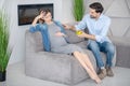 Young bearded man offering apple to his upset wife and smiling Royalty Free Stock Photo