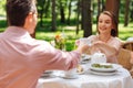 Caring loving wife giving cup of tea to husband