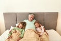 Caring father relax in bed with sick children Royalty Free Stock Photo