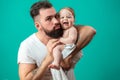 Playful father carrying his smiling infant child on neck over blue background Royalty Free Stock Photo