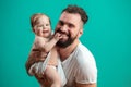 Playful father carrying his smiling infant child on neck over blue background Royalty Free Stock Photo