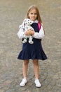 Caring is more gaining. Little child in school uniform hold toy dog outdoors. Pet animal. Friends and friendship. Child Royalty Free Stock Photo