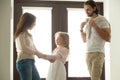 Caring mother helping little daughter dressing for walk with fat Royalty Free Stock Photo