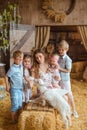 caring mother and her kids, accompanied by a baby, lovingly feed a white kid goat with a bottle of milk Royalty Free Stock Photo