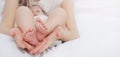 Caring mother holding in hands little foots of her cute baby boy Royalty Free Stock Photo