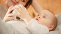 Caring Mother Lying with a Cute Newborn Baby in Bedroom. Mom Bonding with a Toddler, Kissing Infant