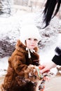 Caring Mother Putting varicoloured Mittens On Child