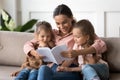 Caring mother reading interesting book to little daughters Royalty Free Stock Photo