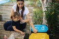 Caring about nature. Young mom with her little daughter preparing for recycling different kind of rubbish and putting Royalty Free Stock Photo