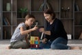 Caring older grandma help granddaughter build from colorful magnetic constructor
