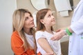 Caring pediatrician taking thermometer in young girl to check temperature