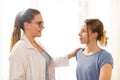 Caring physiotherapist or a doctor consulting with her young female patient at her office.