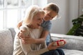 Loving girl hug greeting excited grandmother with anniversary Royalty Free Stock Photo