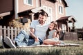 Caring unshaken father sitting and holding monopode. Royalty Free Stock Photo