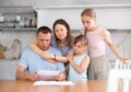 Caring wife and teenage daughters calming upset father sitting with papers