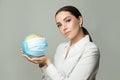 Caring woman holding globe earth in medical protective mask on gray background