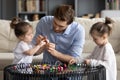 Happy parent involved in handmade activity with small kids girls. Royalty Free Stock Photo