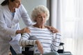 Supportive female nurse take care of disabled elderly woman Royalty Free Stock Photo