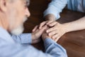 Caring young man adult child hold old man parent hands Royalty Free Stock Photo