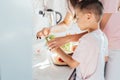 Caring young Mother putting a plaster on child finger with wound on from a cut by kitchen knife. First aid in case Royalty Free Stock Photo