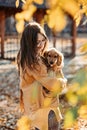 Caring for your pet in autumn, Cute English cocker spaniel puppy walking with female owner in autumn park.