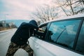 Carjacker aggressively attacking a car owner with a gun, trying to extort money Royalty Free Stock Photo