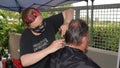 Carlsbad, CA / USA - August 24, 2020: Older man is getting a haircut outside in times of Covid-19 Phase 2 reopening