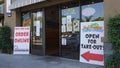 Carlsbad, CA / USA - May 11, 2020: Small restaurants advertise that they are still open for take-out and delivery with large signs