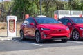 Carlsbad, California - Sept 21, 2021: Tesla Charging station in parking lot of shopping center with two cars