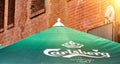 Carlsberg lettering and logo of the Danish brewer on a green parasol in front of a brick facade in Hamburg, Germany, July 22, 2021