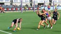 Carlton player Tilly Lucas-Rodd performing a pick up on the run while a teammate Jessica Kennedy blocks an opponent at Ikon Park