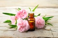Carnation absolute essential oil and pink flowers on the wooden table Royalty Free Stock Photo