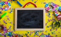 Carnival or birthday party. Blank blackboard, confetti and serpentines on bright yellow background