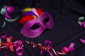 Carnival. Festive background with copy space. Carnival mask with feathers on a black fabric background. Mardi Gras. Brazilian